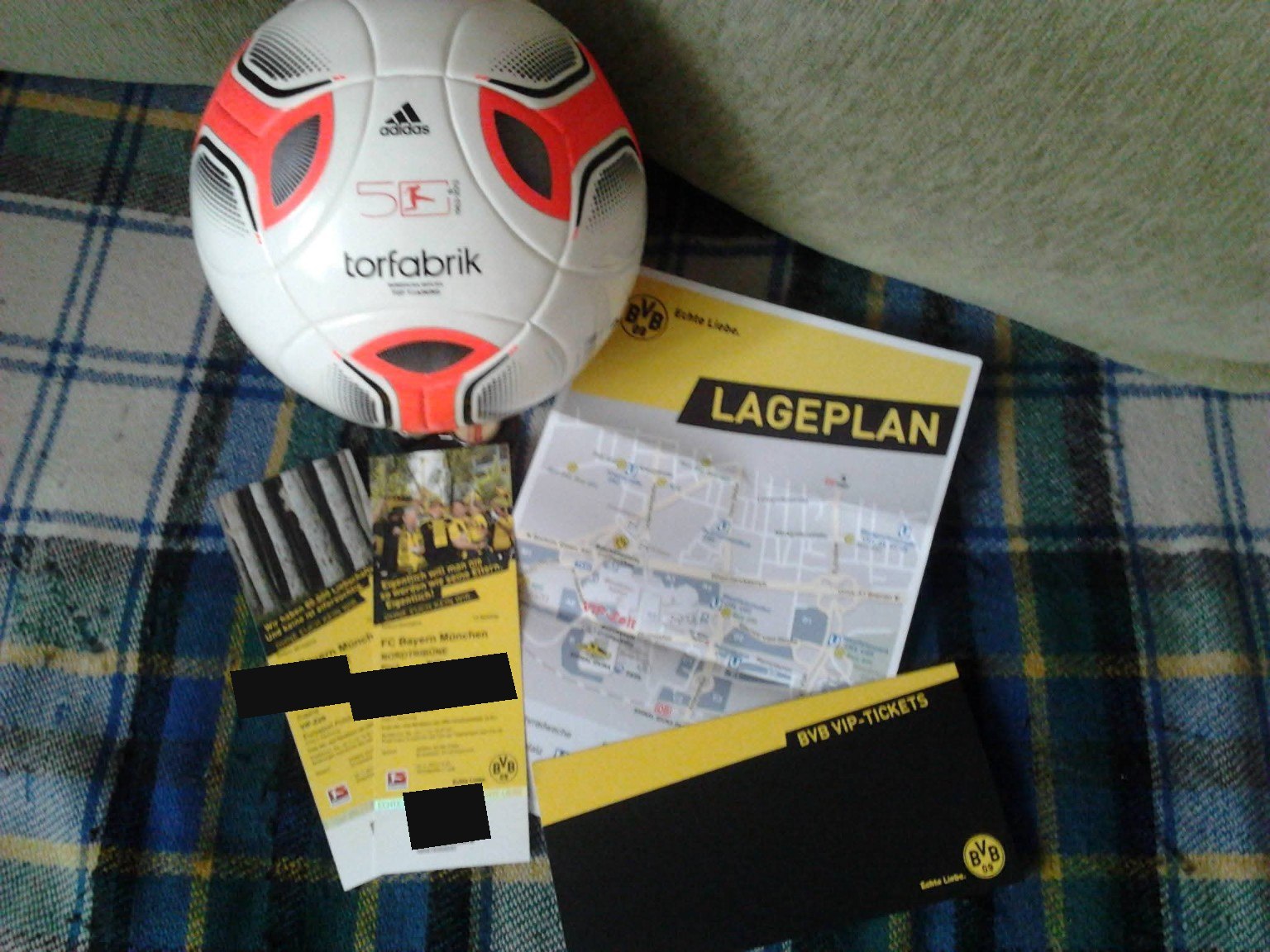 Der Spielball und die VIP-Tickets aus dem Wettbewerb; Plätze und Barcode sind abgedeckt.